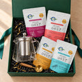 Mindful Moments Gift Box from above with an empty glass kettle, four tea infusions and a gold measuring spoon